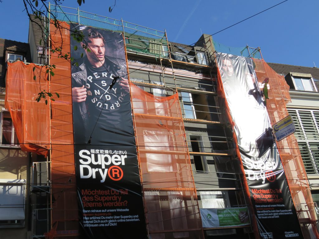 Große Werbebanner kündigen die Eröffnung des Superdry Stores in Freiburg / Bertoldstrasse an